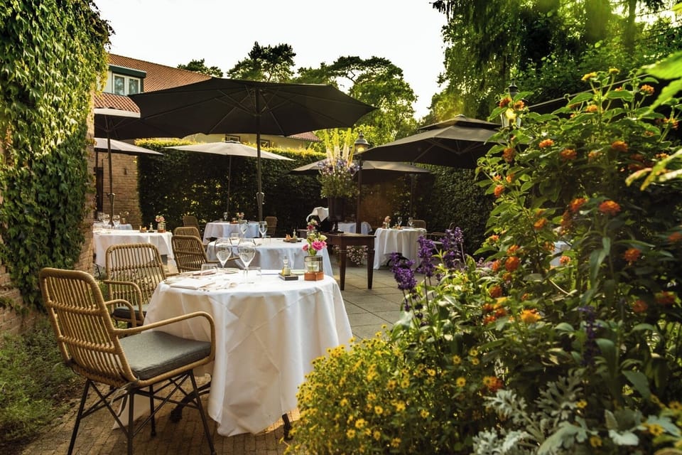 Savor candlelit garden dining beneath shady umbrellas and blooms.