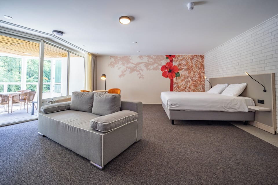 Lounge together in a sunlit suite with expansive windows.