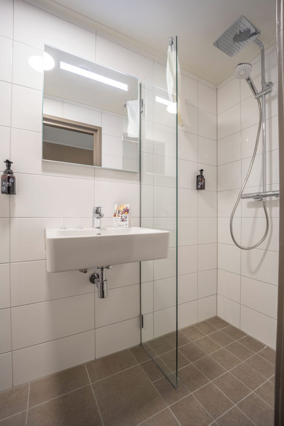 Refresh under a rainfall shower in a spotless bathroom.