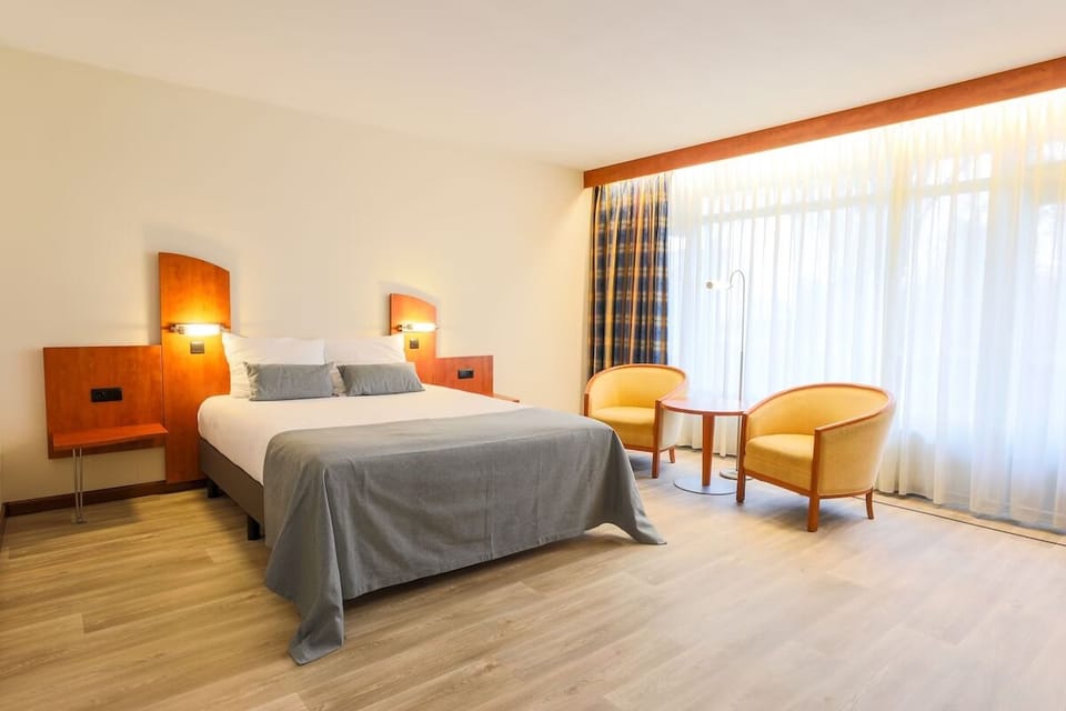 Relax in a bright bedroom with seating by the window.