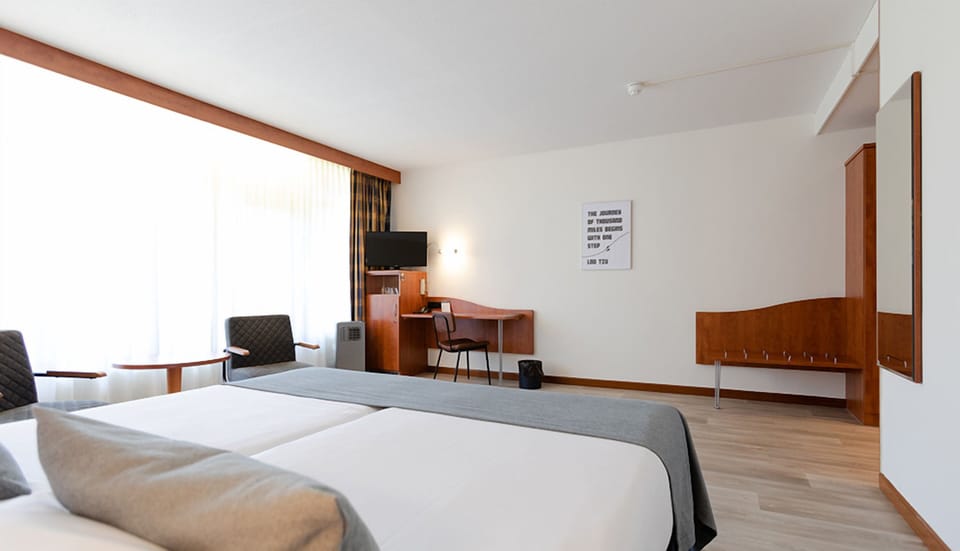 Recharge in a spacious room with desk and TV corner.