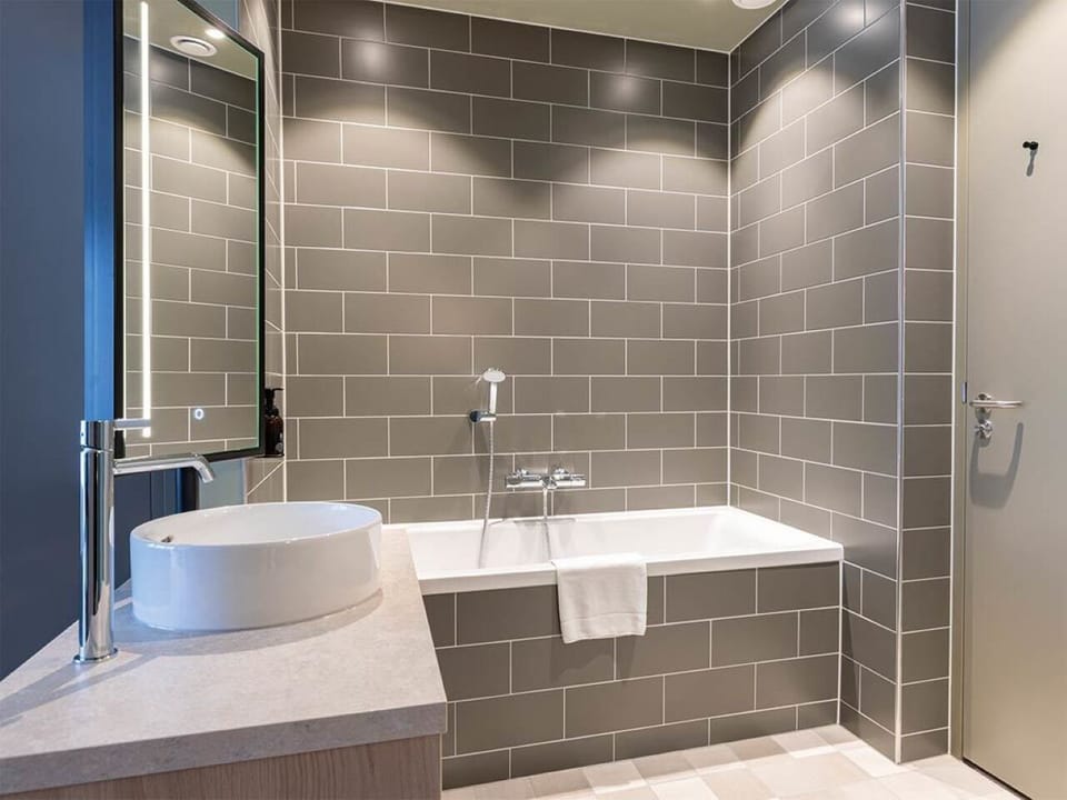 Indulge in a spacious tiled bath with deep tub and vanity.