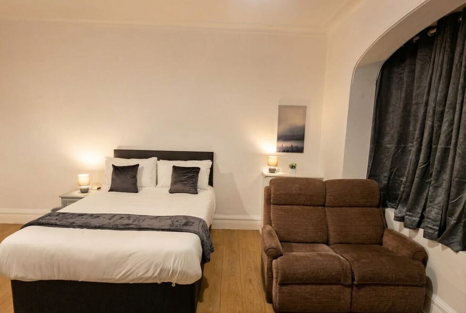 Warm bedside lighting and a plush recliner make this double room feel like your own private retreat.