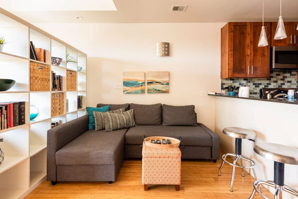 Lounge in style with books, barstools, and a plush sectional that hugs back.