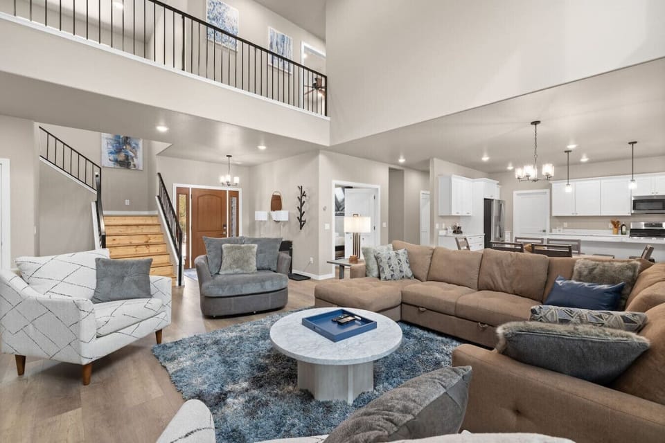 Contemporary décor, a blue-accent rug, abstract artwork, and cozy seating create a space that feels both warm and refined.