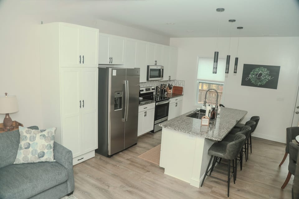A bright, fully stocked kitchen designed for gathering. Stainless appliances, granite countertops, and island seating invite slow breakfasts, shared meals, and effortless entertaining with seating and place settings for eight.