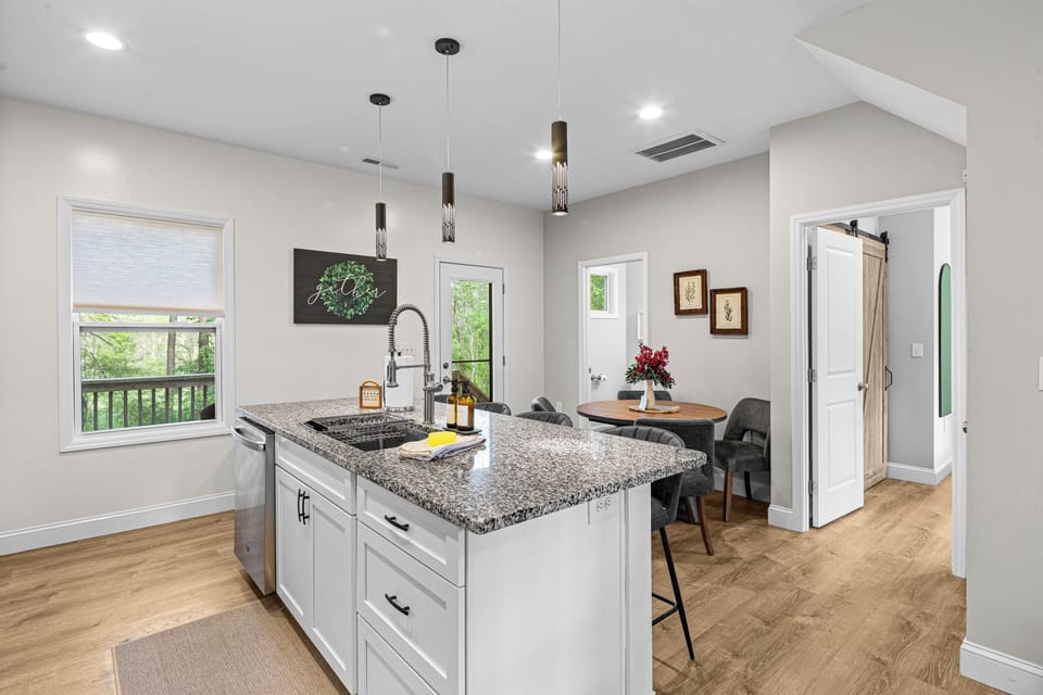A bright, open-concept kitchen designed for gathering—featuring sleek finishes, ample seating, and seamless flow into dining and living spaces. Perfect for shared meals, morning coffee, and relaxed evenings in.