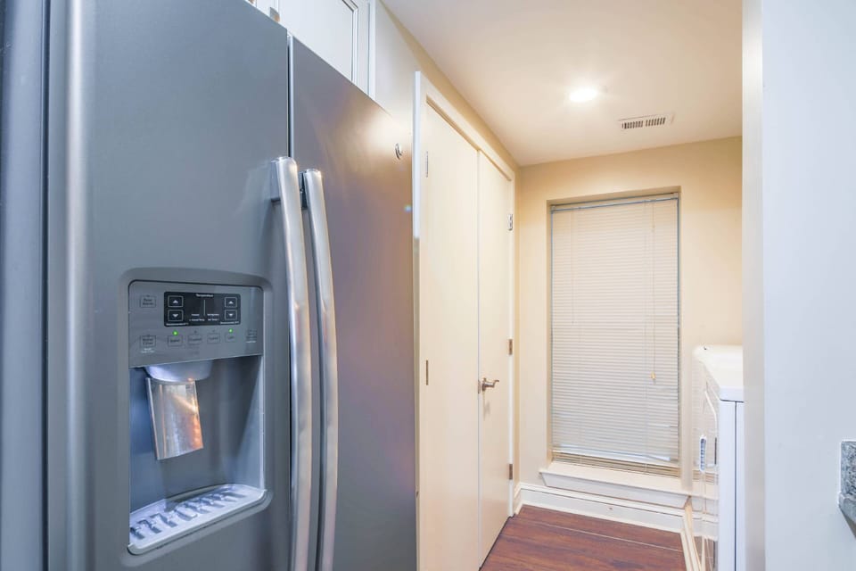 The washing machine and dryer are tucked away just beyond the refrigerator.