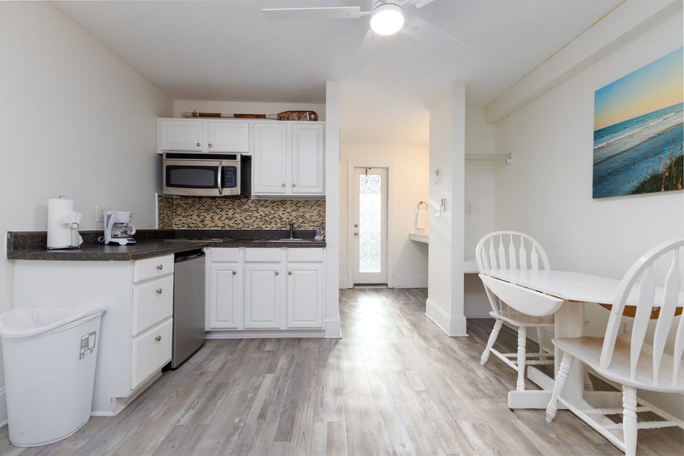 Fully equipped kitchenette with microwave, mini fridge, coffee maker, and dining space for easy meals and morning coffee.