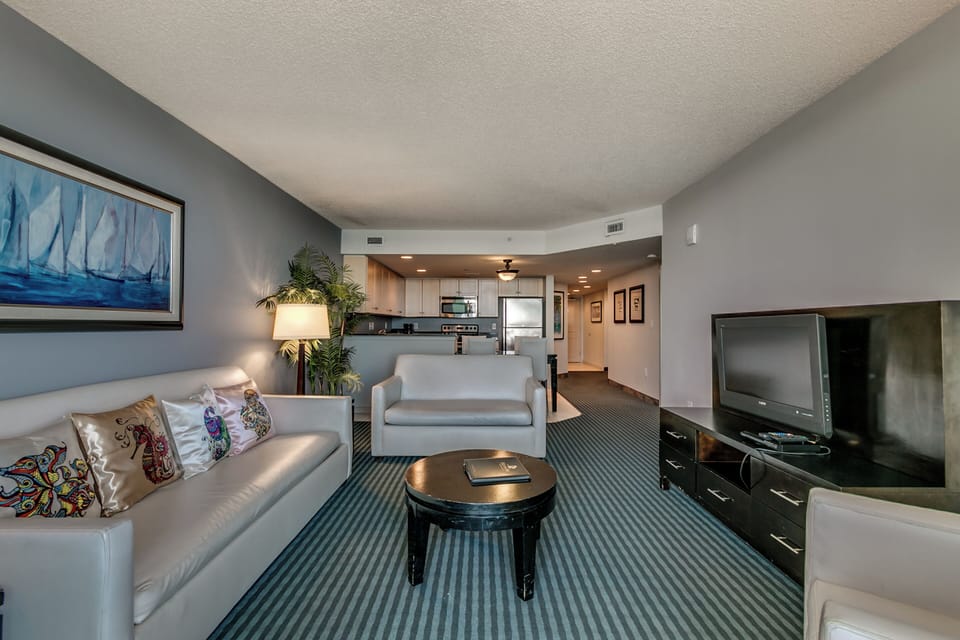 Living area with oceanfront balcony access, tasteful decor,  relaxing ambiance