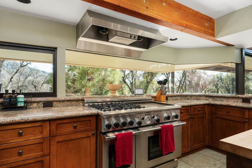 Commercial grade Thermador stove with two ovens, four gas burners, and large griddle for group meals
