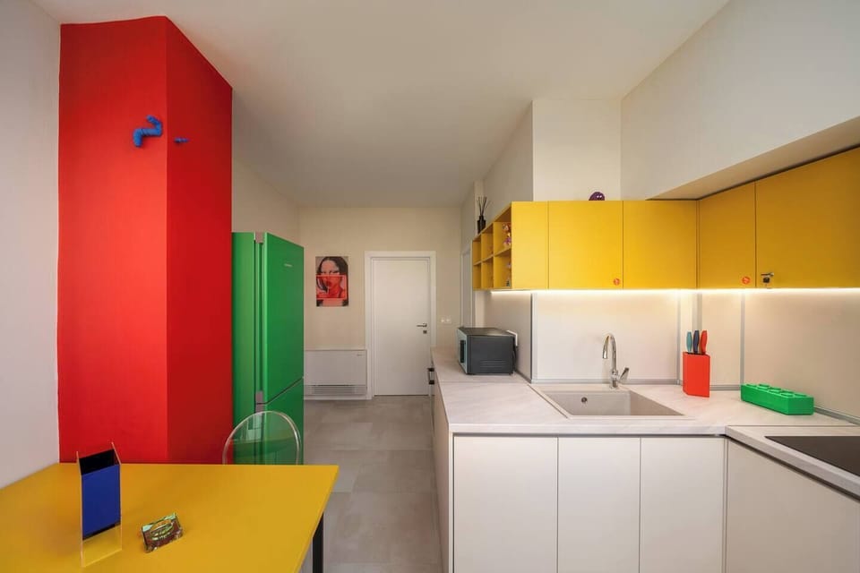 Colour-blocked and fully loaded — a bright, modern kitchen where the green fridge is always the star of the room