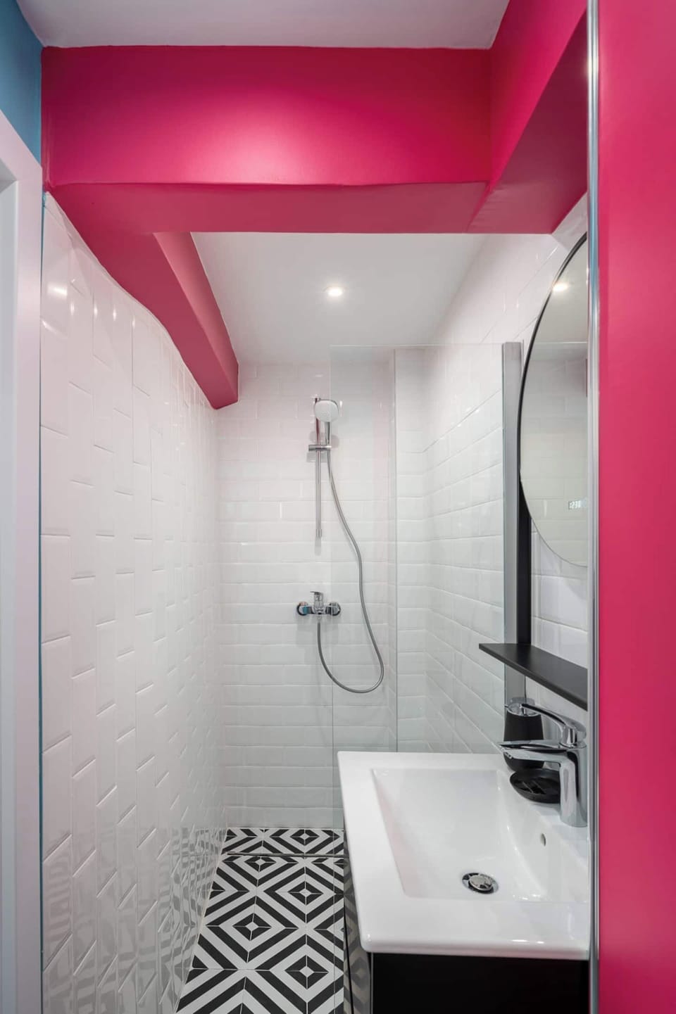 A shower with a point of view — clean, modern, and finished with a hot-pink accent that keeps the energy alive