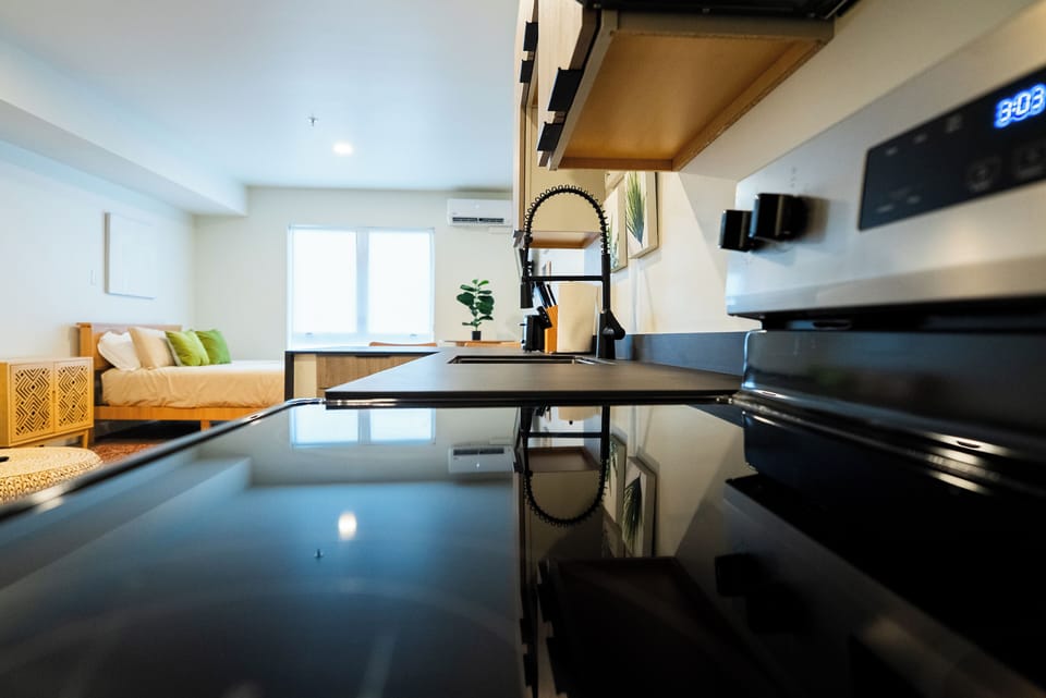 Your sleek modern kitchen features gleaming black countertops and professional-grade fixtures, perfect for preparing meals in style.