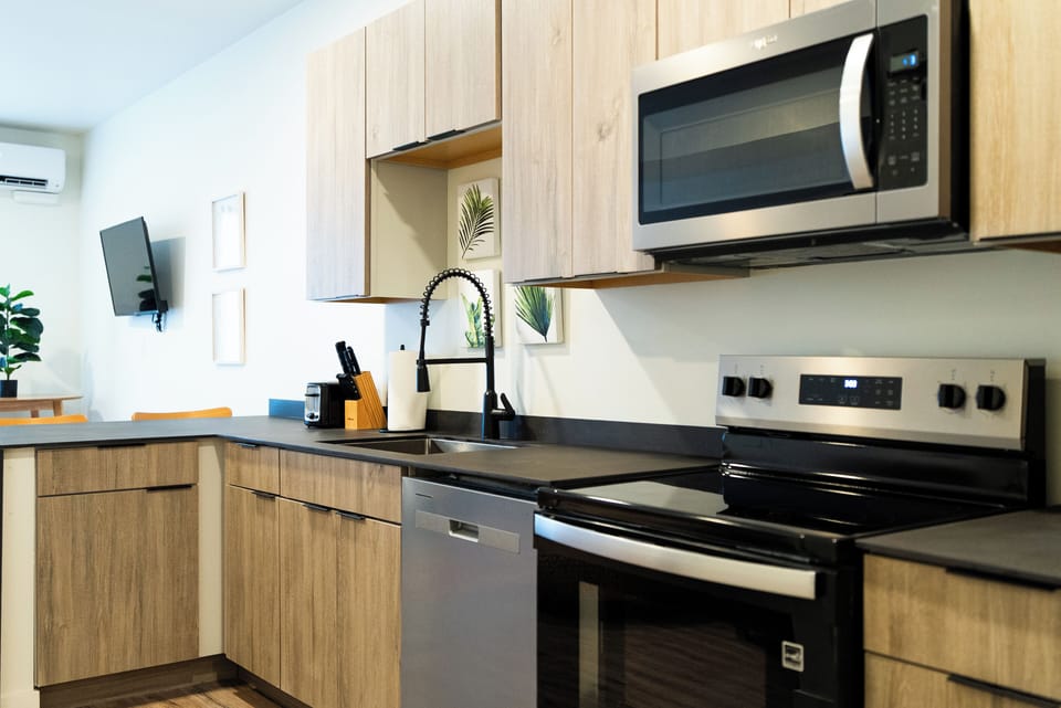 Your modern kitchen awaits with sleek appliances, warm wood cabinetry, and everything you need to create memorable meals during your stay.