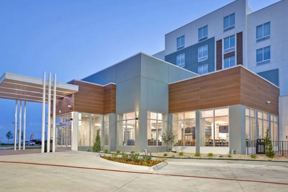 Pull up to a sleek, modern exterior glowing at dusk.