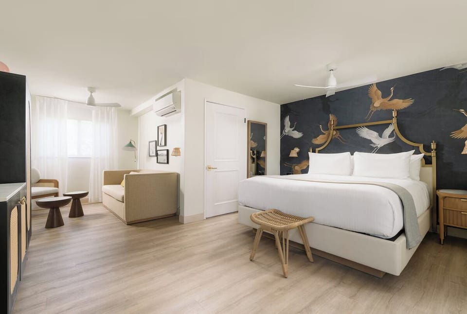 Unwind in a sunlit king bed with stylish lounge seating.