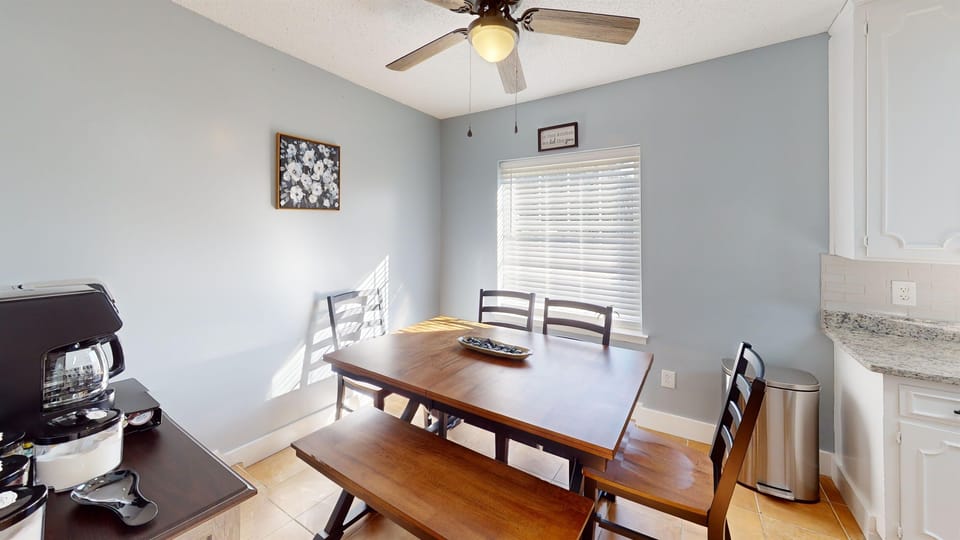 The dining area includes a large dining table and a coffee bar