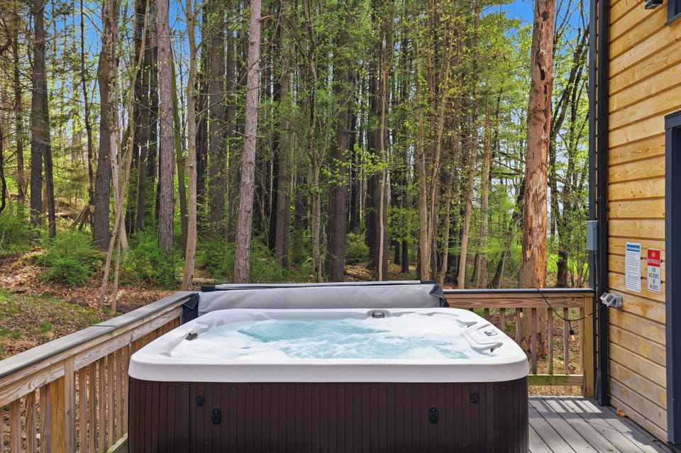Private deck with a relaxing hot tub nestled among the trees.