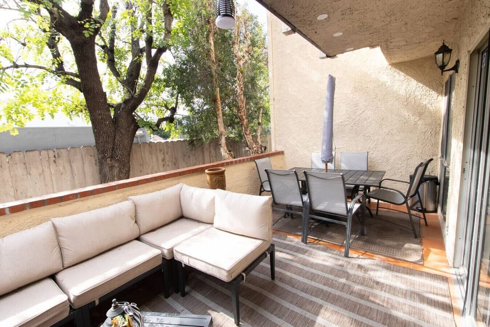 Enjoy indoor-outdoor living on this furnished patio, perfect for meals and relaxing in the shade.