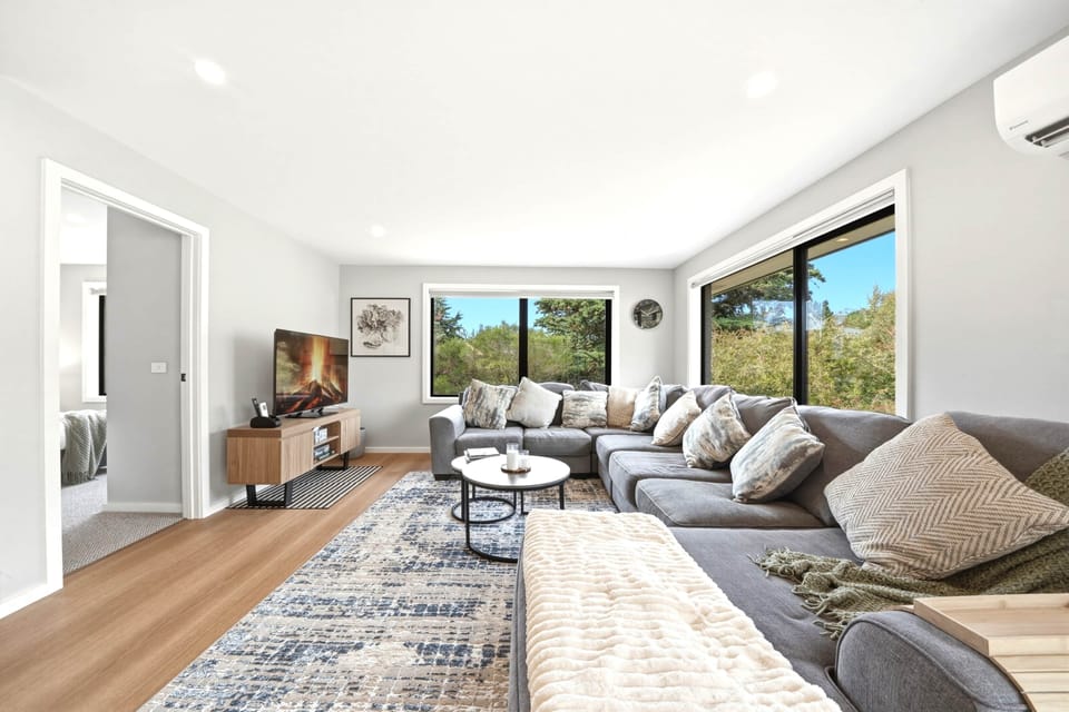 Bright living room with natural light and leafy outlook.