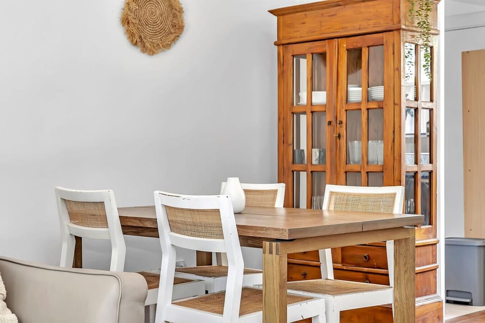 Enjoy home-cooked meals at our solid timber dining table, styled with comfortable woven seating.