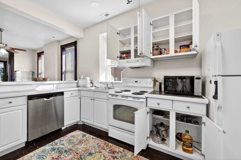 A bright, thoughtfully stocked kitchen with crisp cabinetry and everything you need to cook, gather, and feel at home.