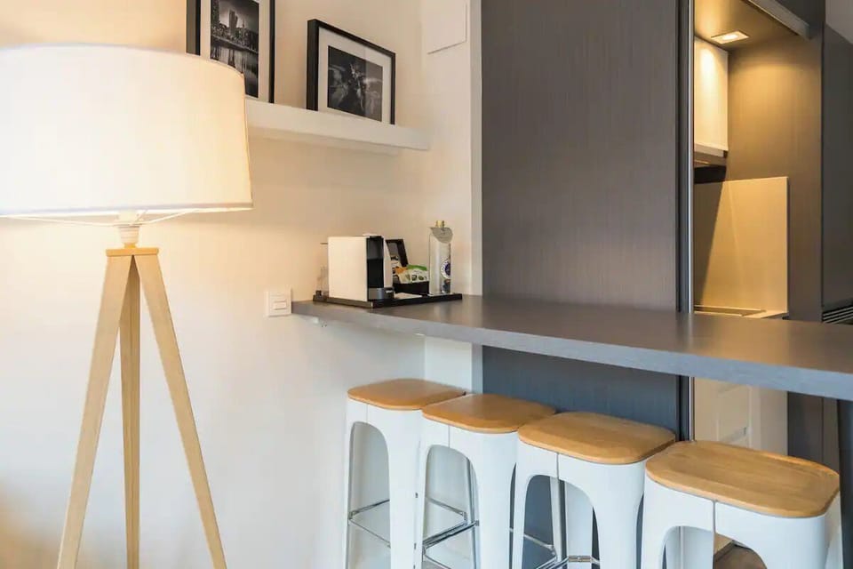 Relax in a calm, airy room with warm bedside lighting.