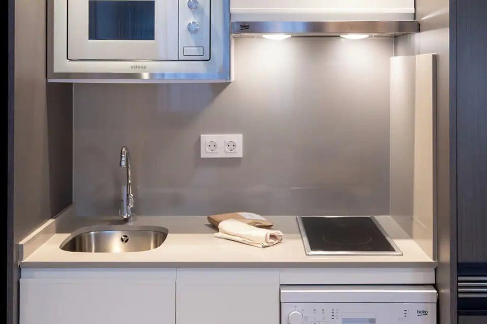 Prepare simple bites with a modern hob, sink, and microwave.
