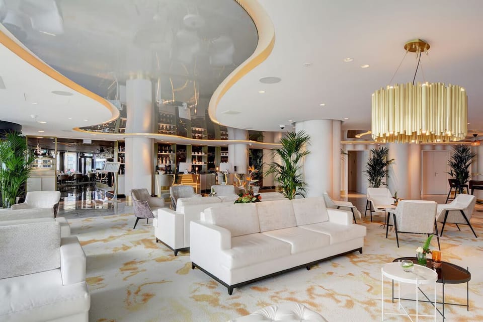 Unwind on plush sofas beneath glowing, modern designer lighting.