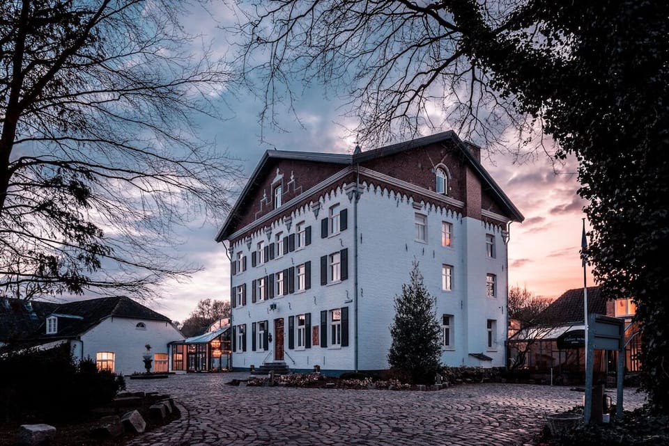 Arrive to a storybook estate glowing warmly at sunset.