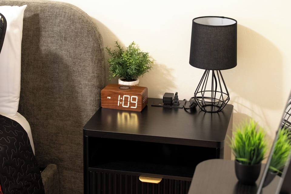Wind down with a clean bedside setup and warm lamplight