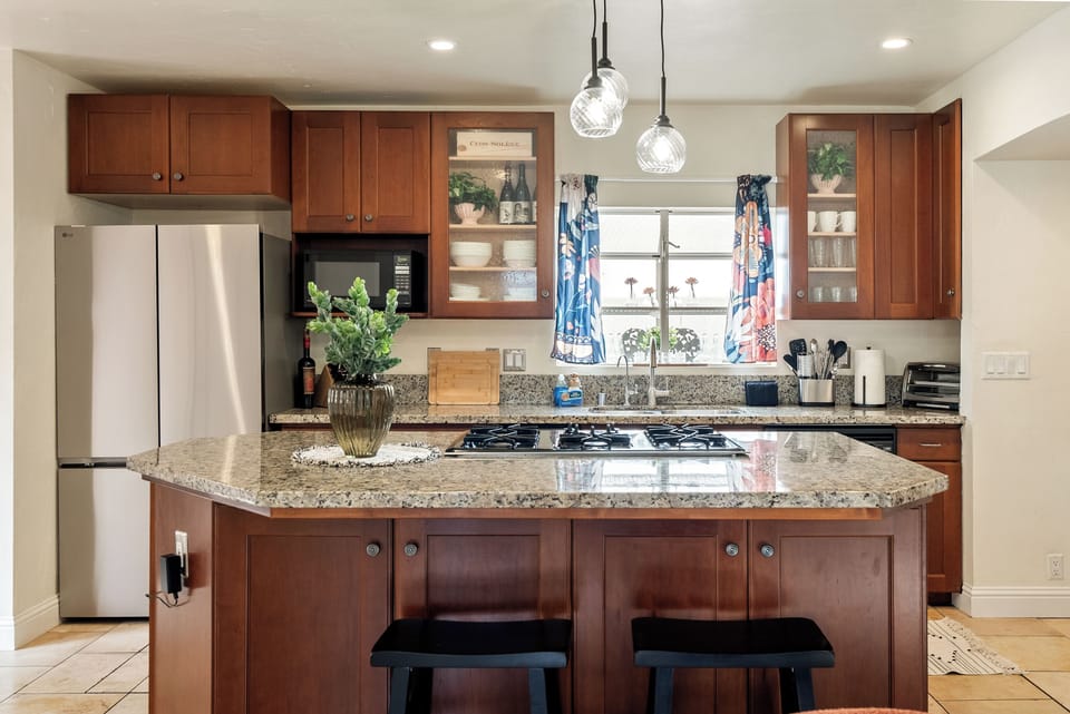 Kitchen - Large island with 5 gas burners surrounded by granite countertops