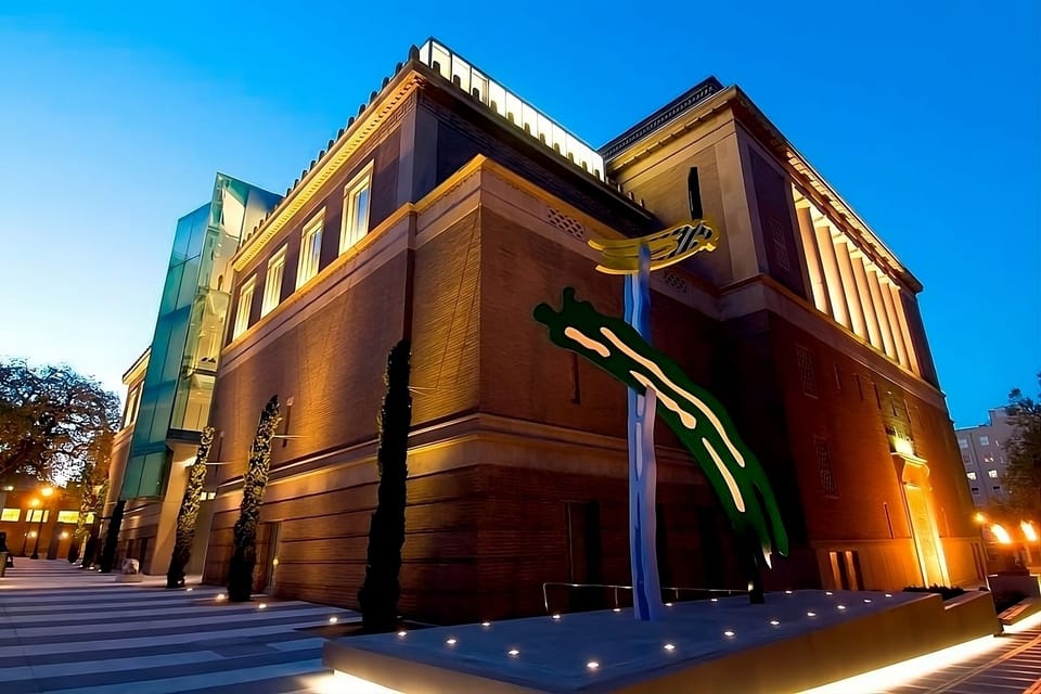 Step into an iconic evening glow beside striking modern architecture.