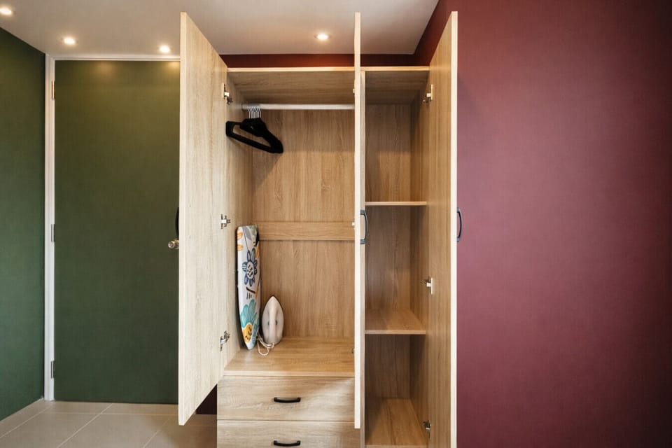 Spacious wardrobe with hangers, shelving, and ironing essentials—perfect for business or extended stays.
