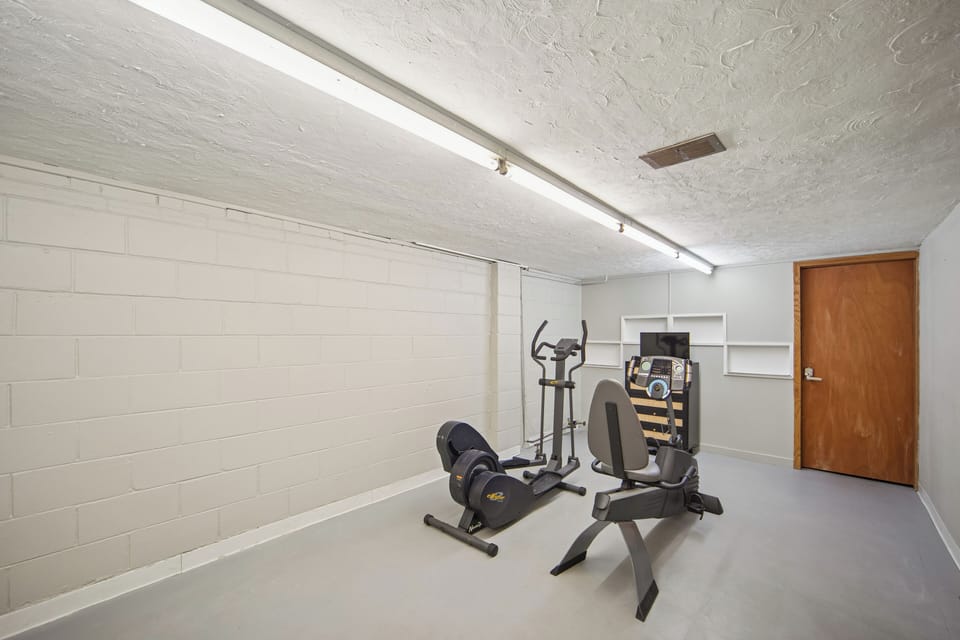 Basement workout area with equipment and a TV to keep your routine going.  