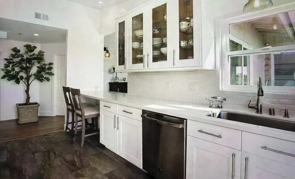 Coastal kitchen glowing with beach light opens to private ocean-view balcony.