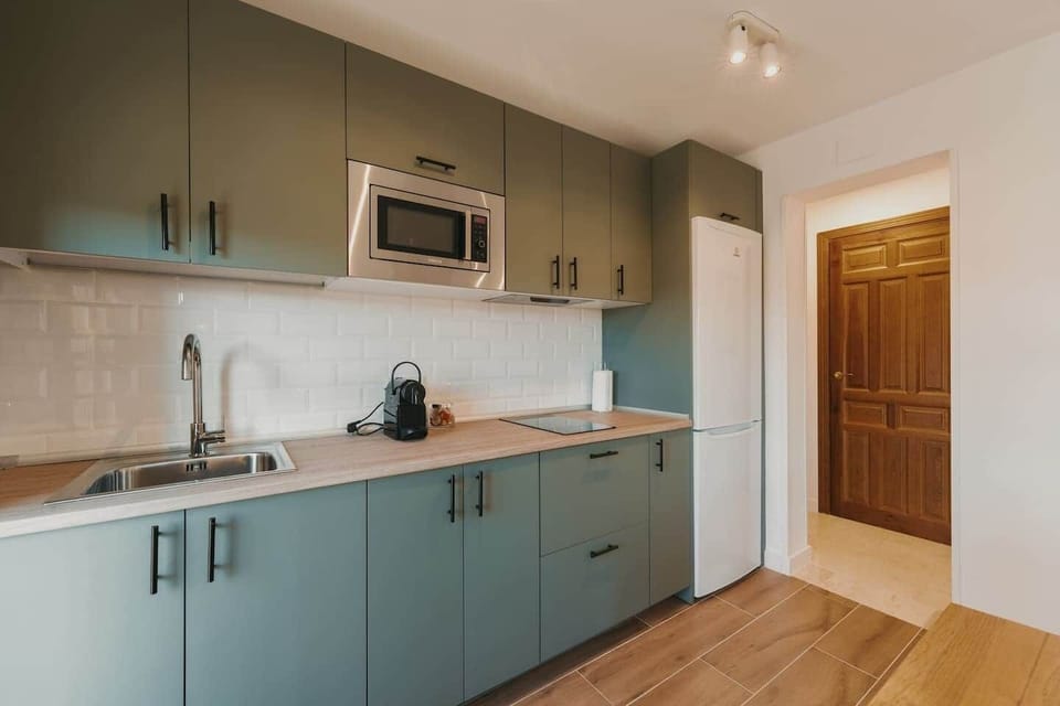 Cocina equipada con microondas, vitrocerámica y nevera