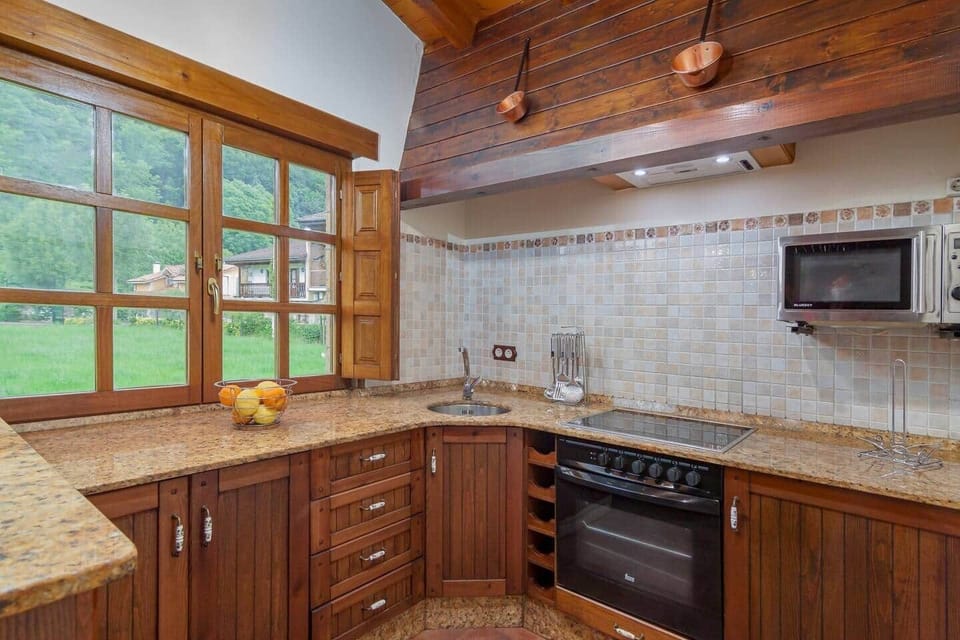 Cocina de madera con vitrocerámica, horno y microondas