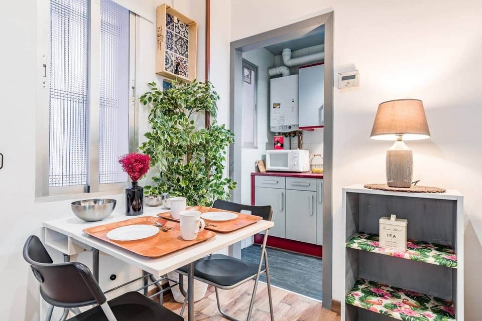 Comedor con mesa, sillas y cocina al fondo