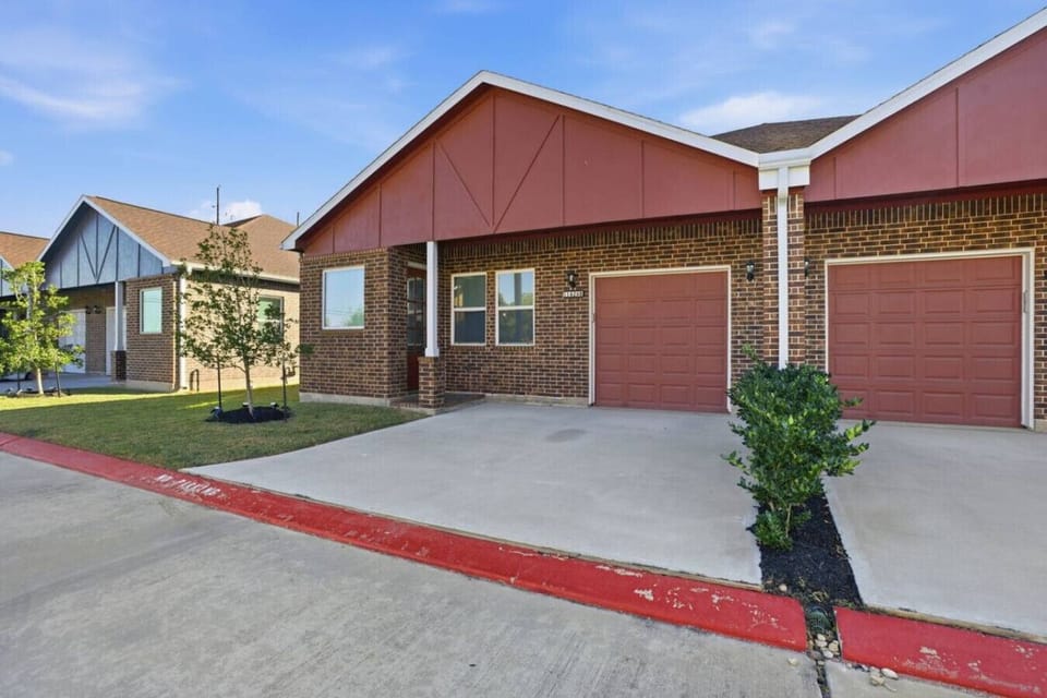 Modern townhome exterior with private driveway, attached garage, and easy walk-up entry. Enjoy convenient parking, a quiet residential setting, and quick access inside—perfect for stress-free arrivals and smooth departures.