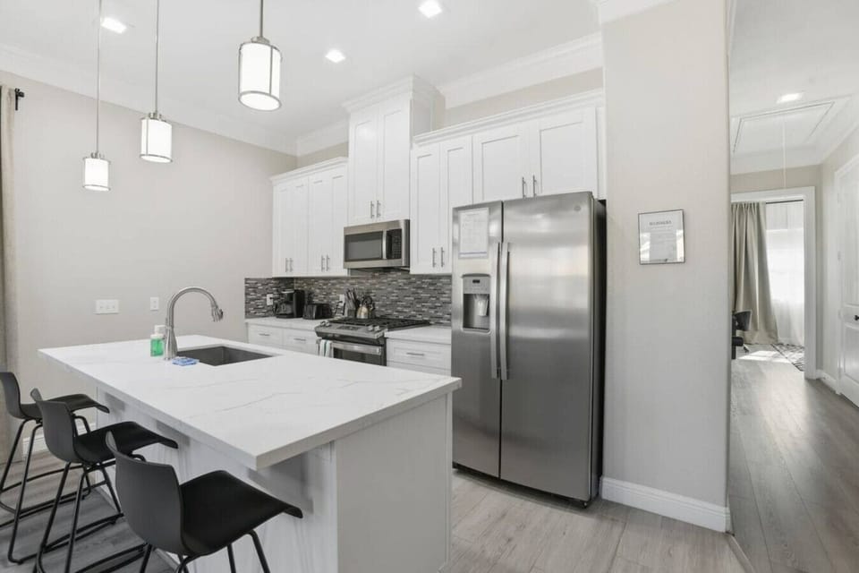 Modern kitchen with oversized island, pendant lighting, and stainless steel appliances. Enjoy easy meal prep, quick breakfasts at the bar, and an open layout that keeps everyone connected—perfect for group trips, family stays, or extended visits.