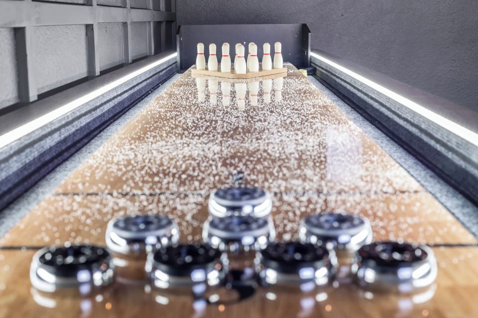 Fun game room featuring a full shuffleboard table for entertainment.
