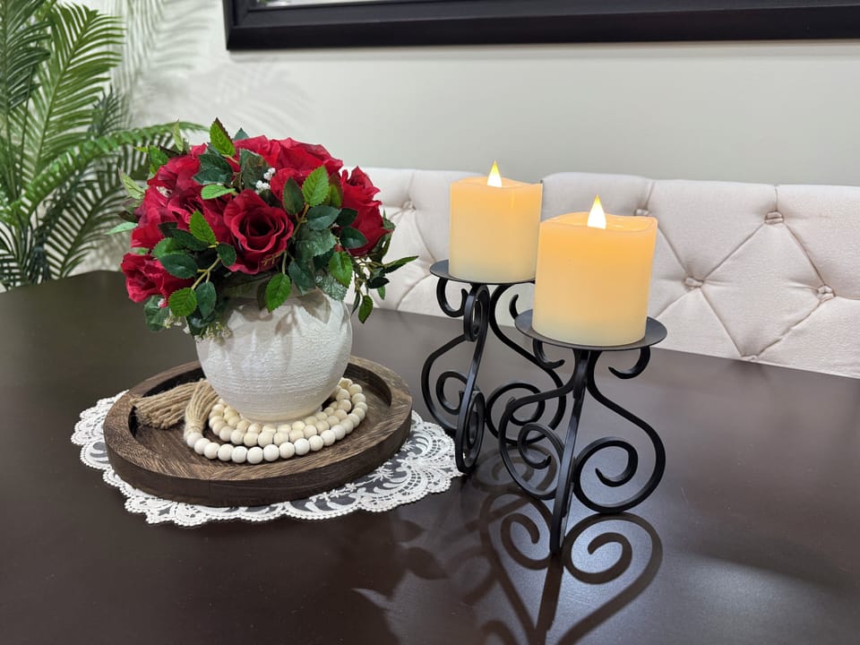 Dining table centerpiece with flowers, candles, and warm décor.