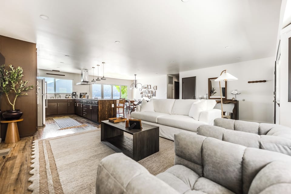 Open concept living room w/ custom down alternative couch & 2 swivel love-seats.
