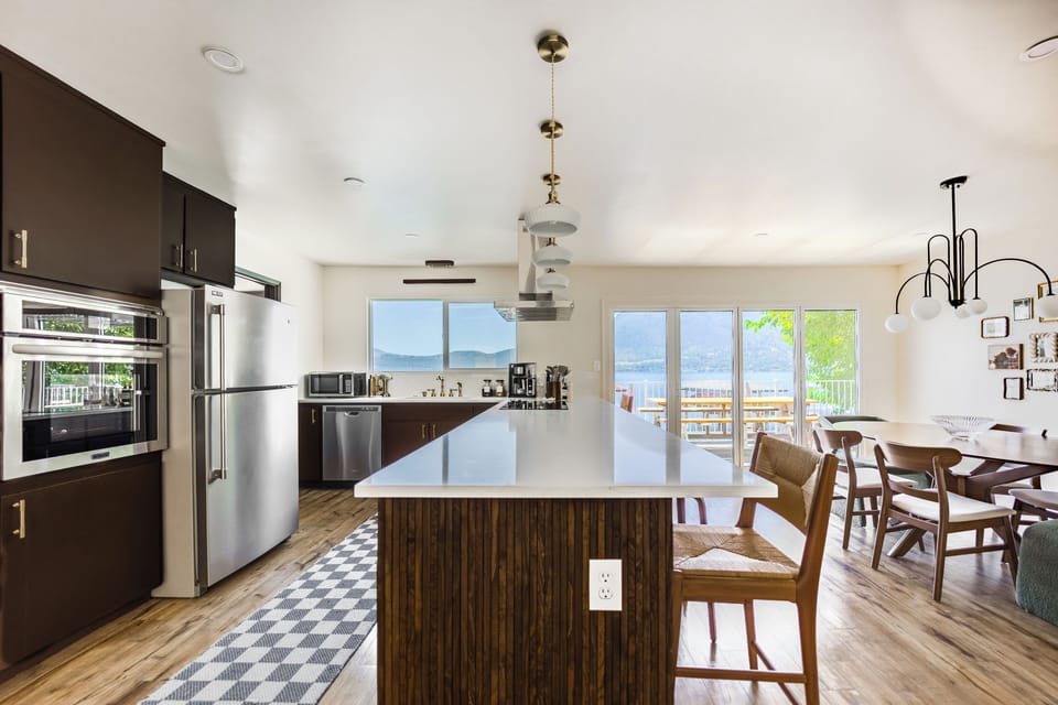 Lux quartz bar top, with 6 bar stools, natural light, & ample space for cooking.