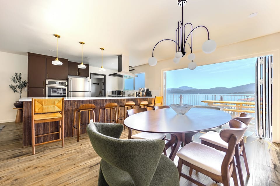 Wooden dining table with 6 seats, that can be formally set for dinner w/ a view.