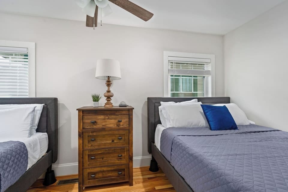 Comfortable and well-lit, this bedroom features two queen beds and minimalistic decor, providing a calm space for guests