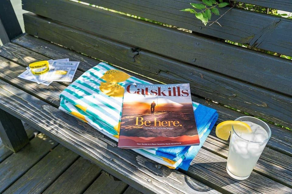 Beach towels, lemonade, and a Catskills guide set the scene for a lakeside getaway. - Catskills Getaway - The Billingswood - Athens, NY
