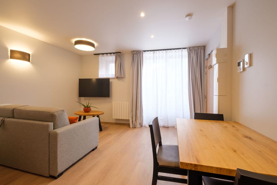 This bright open-plan space combines the dining area and seating, offering a welcoming and functional studio layout.